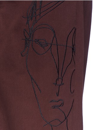 Detail View - Click To Enlarge - SIKI IM / DEN IM - 'Ponyboy' face embroidered frayed cuff chinos